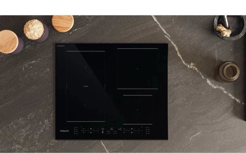 Hotpoint TB 2560C CPBF 59cm 4 Zone Induction Hob in Black promotion photo of hob on worktop with wooden utensils
