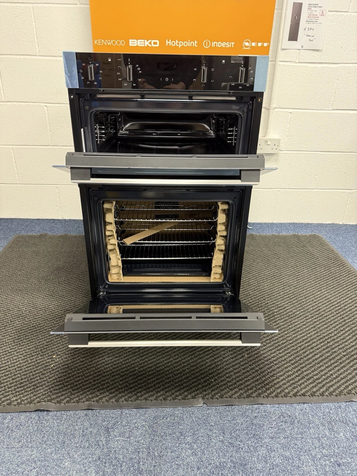 Neff N50 U1ACE2AN3B Built-in Electric Double Oven in Stainless Steel - A/B Rated by HomeWise Appliances. Showroom photo with doors open.