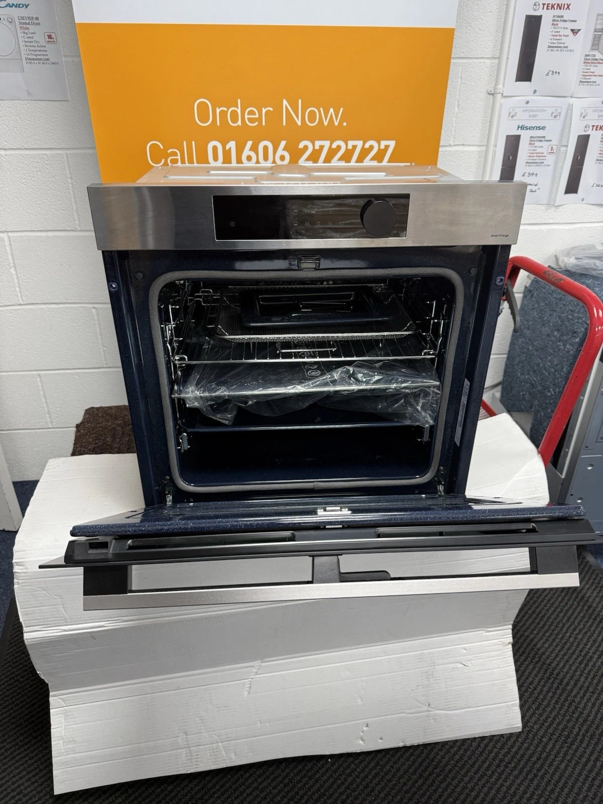 Samsung NV7B5755SAS Flexible Dual Cook Built-in Smart Single Oven with Pyrolytic Self Cleaning and Air Fry in Stainless Steel - A+ Rated from HomeWise Appliances. Shop photo of front of the oven with door open showing interior accessories.