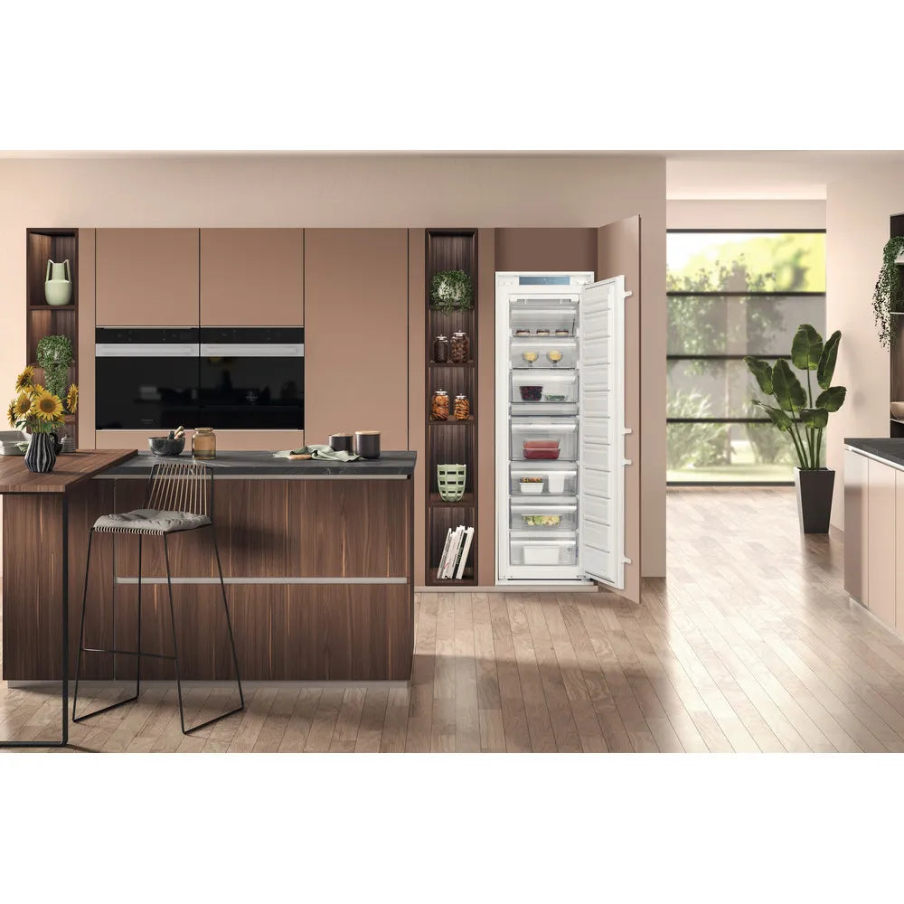 Hotpoint HTSD18F013H1 209 Litre Tall Built-In Freezer with No Frost - E Rated from HomeWise Appliances. Stock photo of the freezer with door open in a kitchen environment.