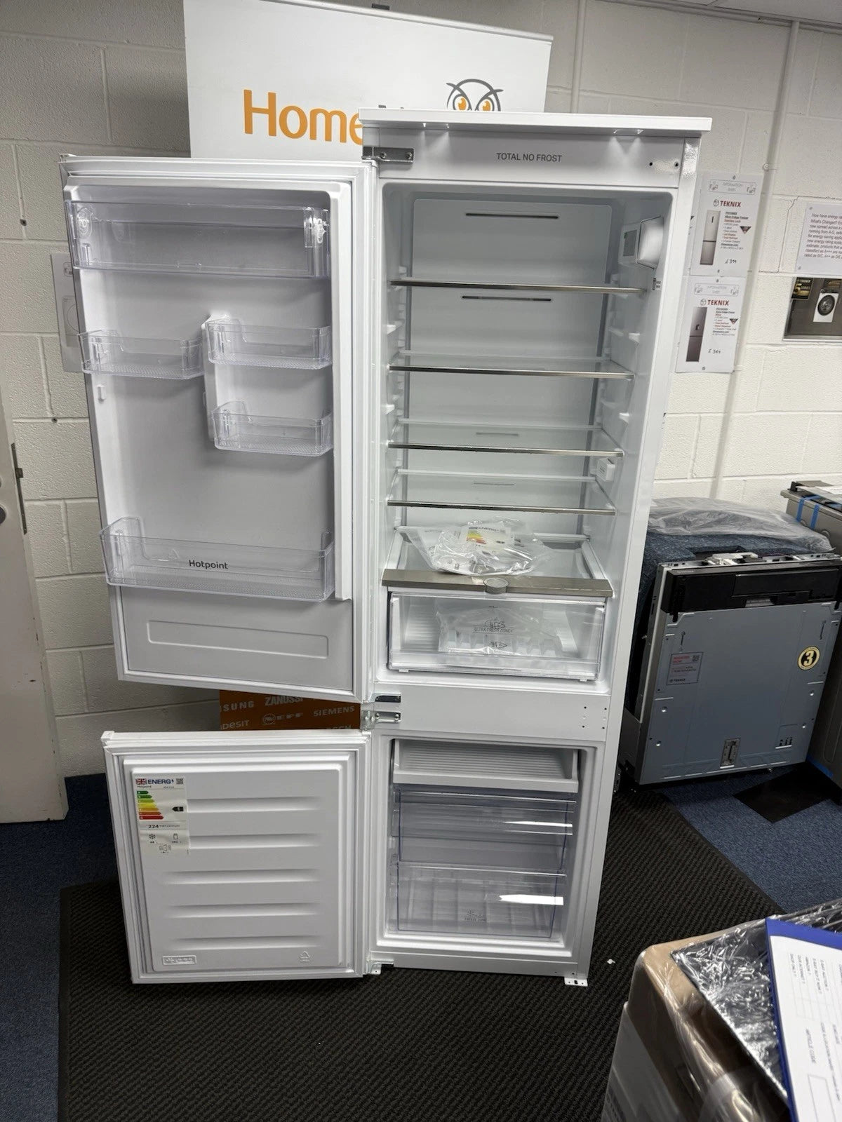 Hotpoint HTC18 T112 UK 70/30 No Frost Integrated Fridge Freezer with Sliding Hinge - E Rated from HomeWise Appliances. Shop photo of the front with the doors open showing the interior contents.