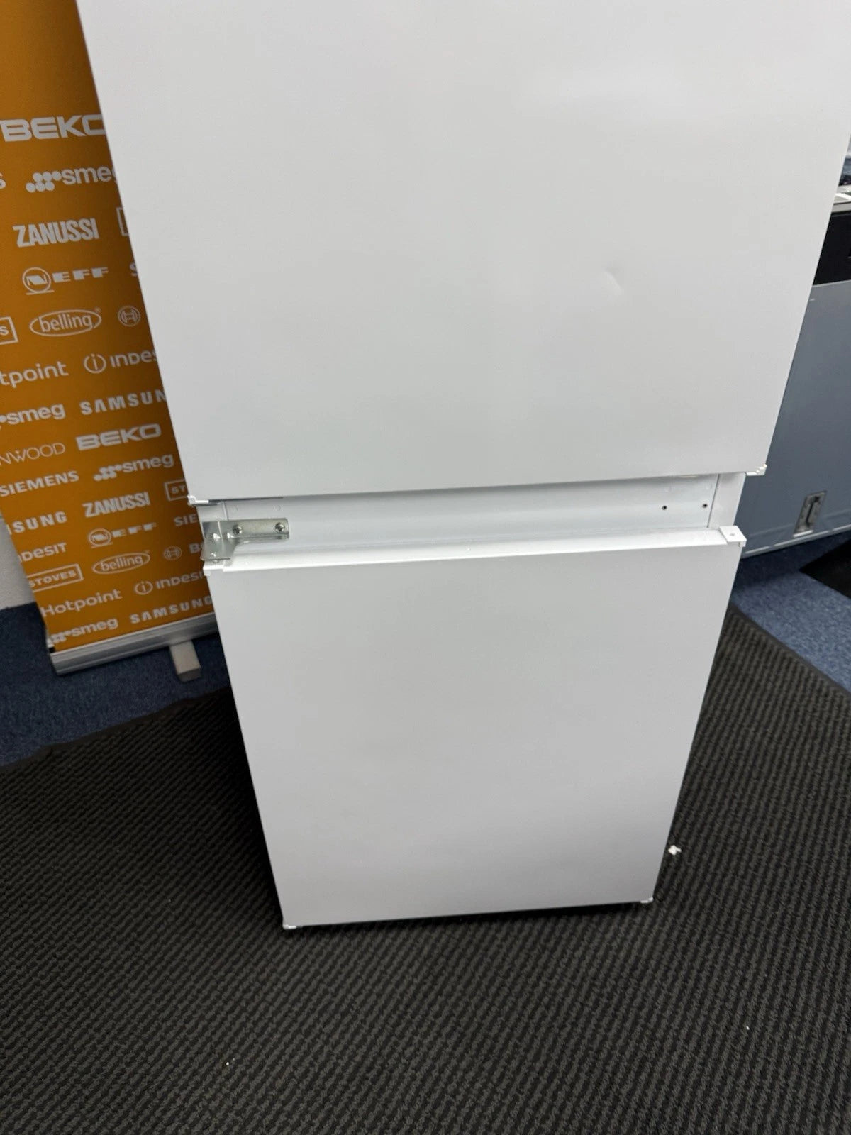 Hotpoint HTC18 T112 UK 70/30 No Frost Integrated Fridge Freezer with Sliding Hinge - E Rated from HomeWise Appliances. Shop photo close up of the exterior of doors, small marks will not be seen when installed.