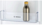 Bosch Series 2 KIV87NSE0G (09) 270 Litre 70/30 Integrated Fridge Freezer - E Rated from HomeWise Appliances. Stock photo showing a bottle in the side door holders.